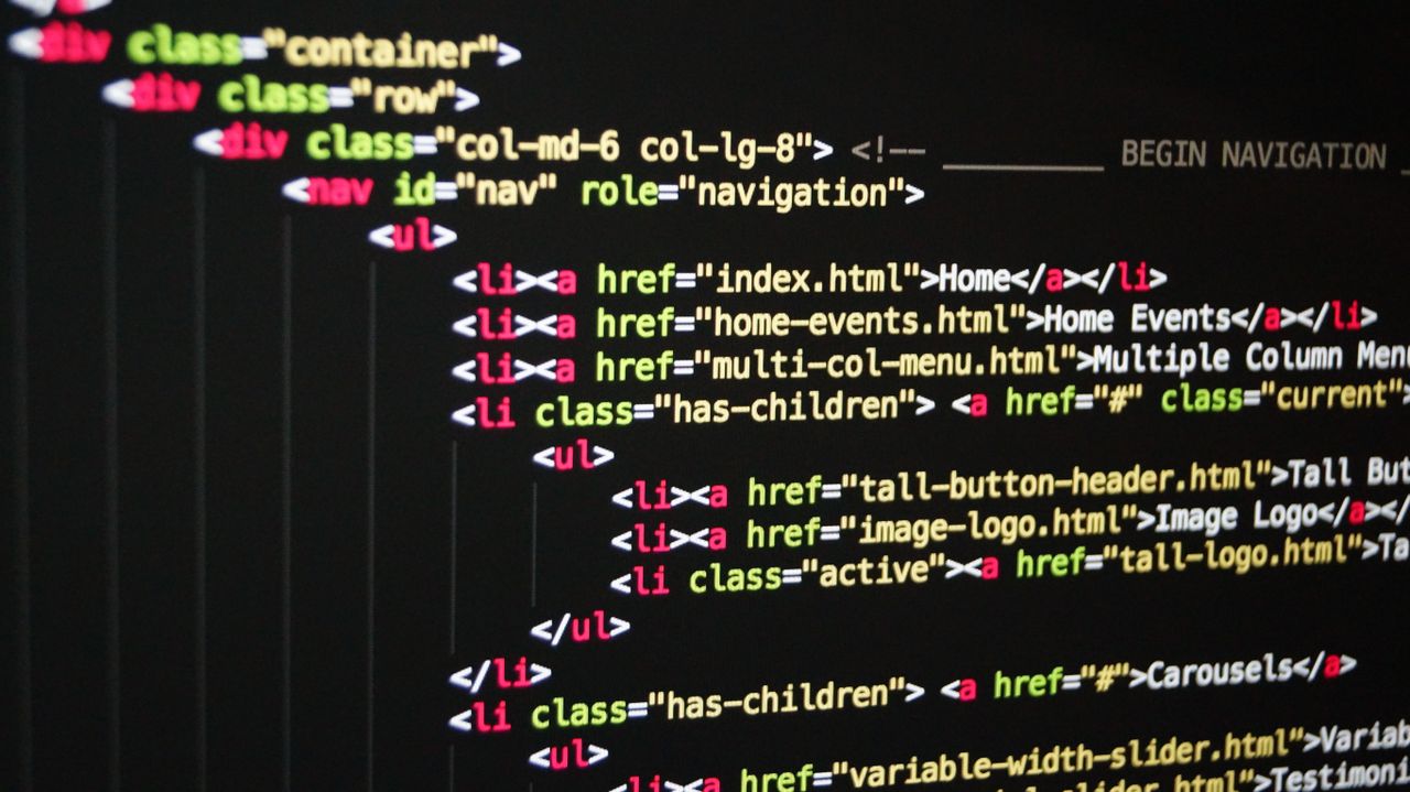 Gros plan sur un code HTML éclatant affiché à l’écran d’un ordinateur, mettant en avant le développement web et la programmation.